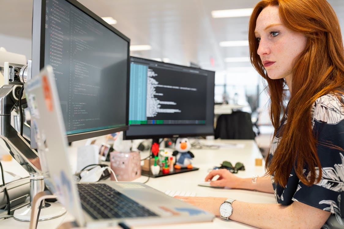 A woman coding on a computer in her new office.