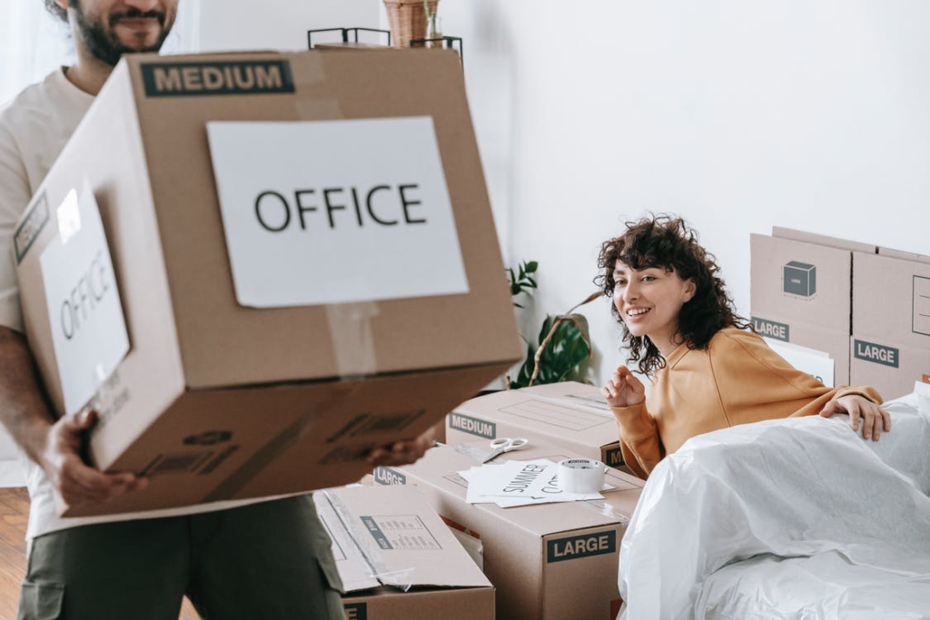 A man and a woman packing and moving boxes