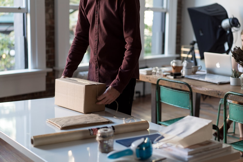 A person packing a box in an office  