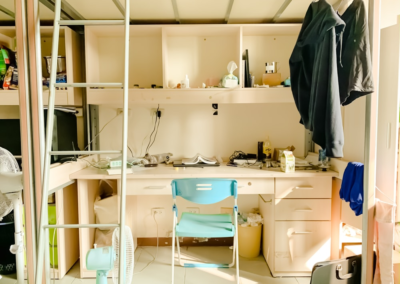 A study desk under a bed in a dorm room