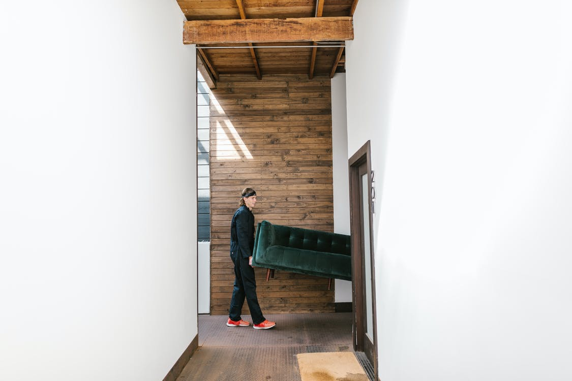 Professional movers carrying a couch into a room