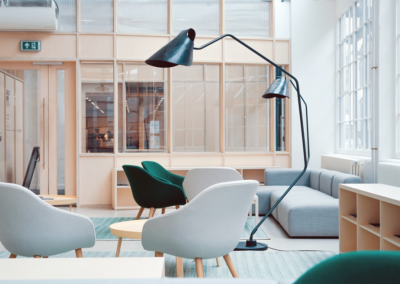 A modern office with chairs and a curved lamp