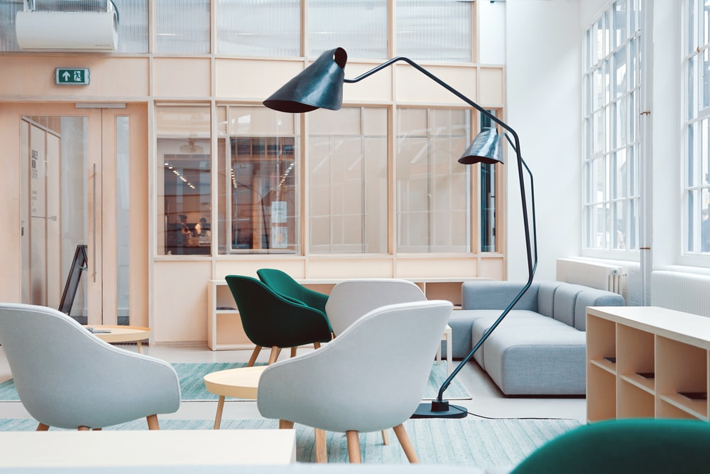 A modern office with chairs and a curved lamp