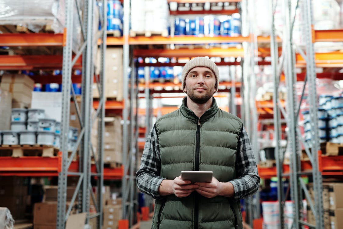 A warehouse manager holding a digital tablet