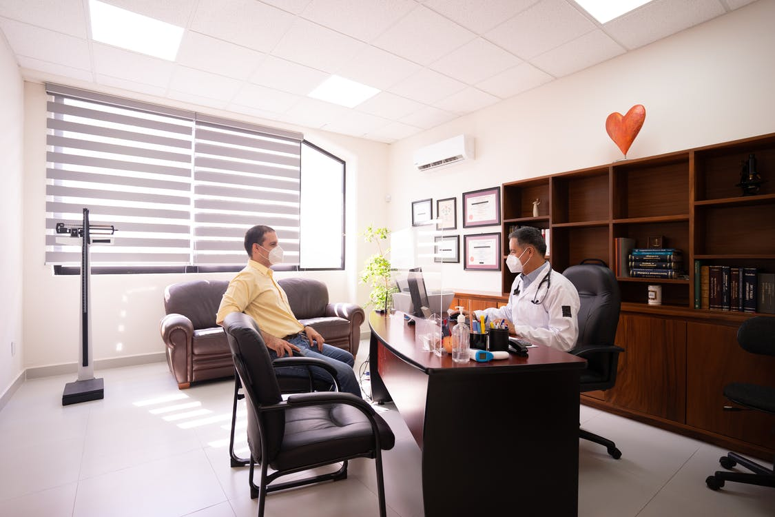 A patient consulting with a doctor in his office