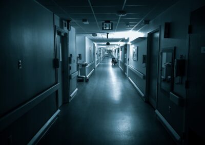 A dimly lit hospital hallway with closed doors