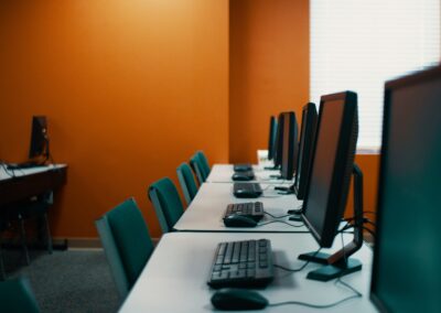 Several computers are lined up on a white desk