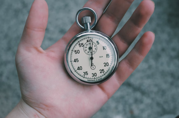 A person holding a stopwatch in their hands. 