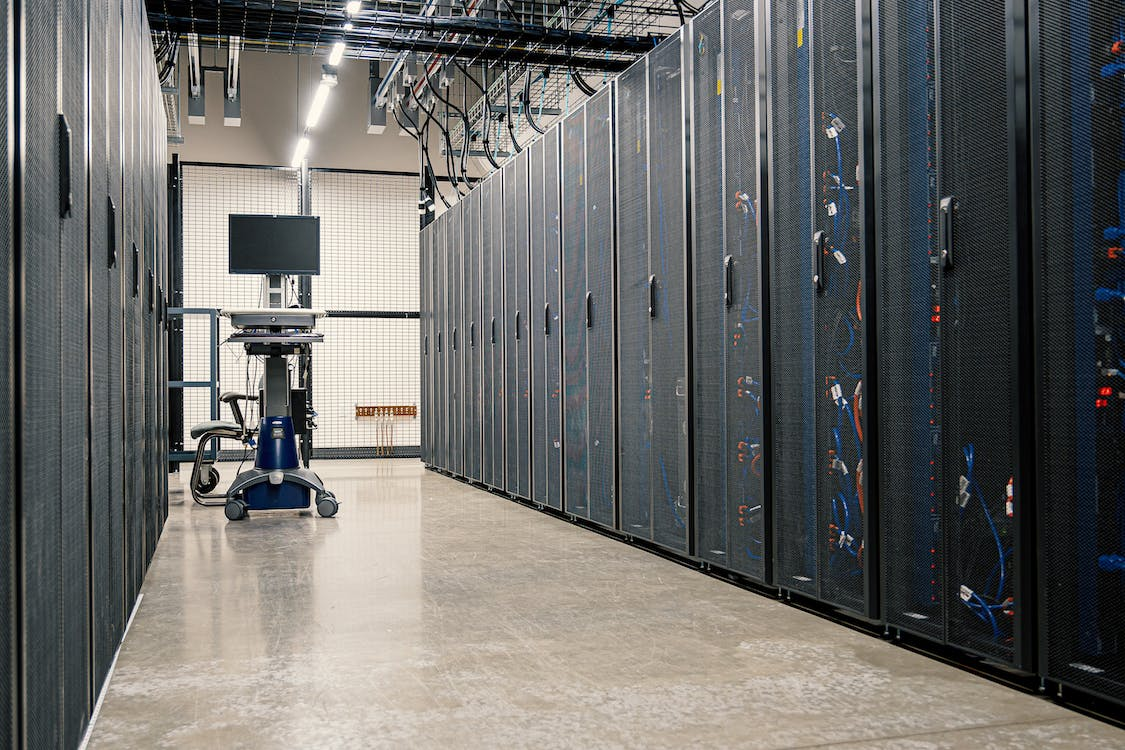 A large and empty data center room with a computer placed in the middle.