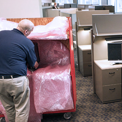 A man packing different pieces of equipment and loading them onto a cart.