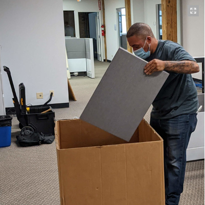  a person packing things in a large box. 