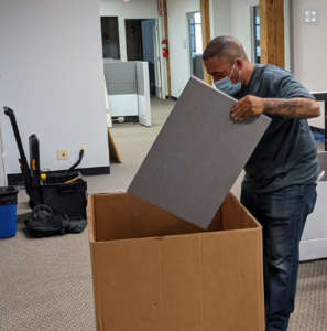 A person packing office equipment in a box.