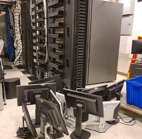 Several pieces of technical equipment lying around on the floor next to a large server. 