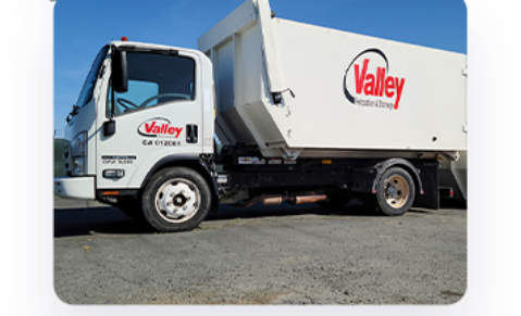 A large white disposal van with a Valley Relocation logo on it. 