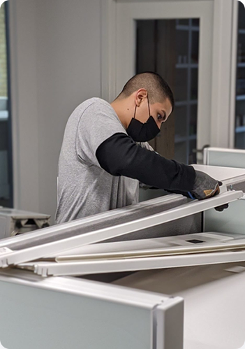 A man assembling a piece of cubicle for the office. 