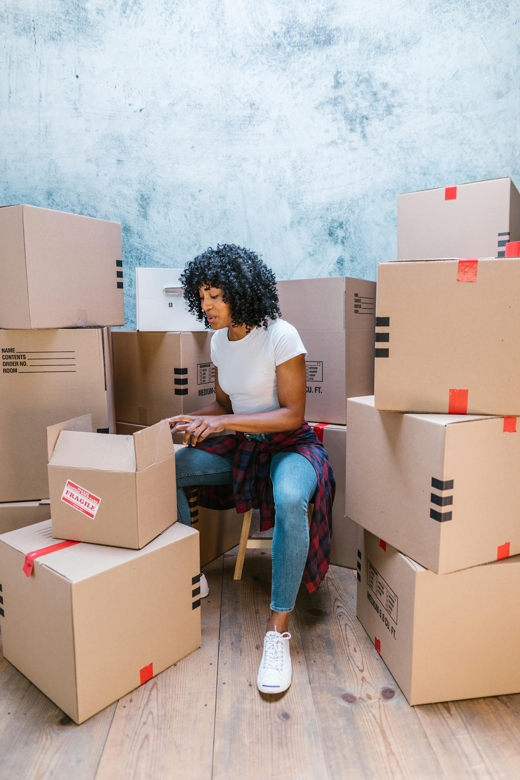A woman surrounded by moving boxes.