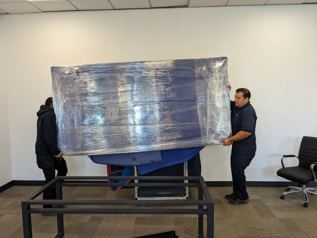 People carrying large office equipment.