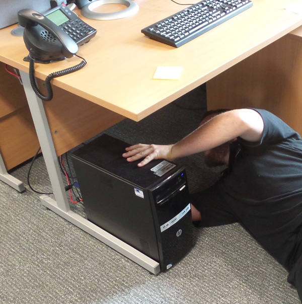  A man lying on the floor working with equipment. 