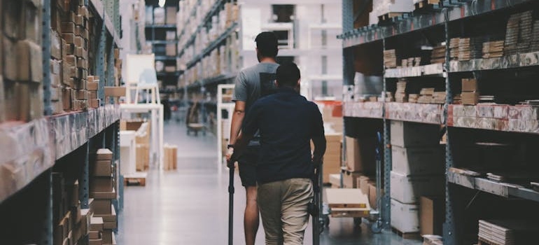 Two men walking around a warehouse.