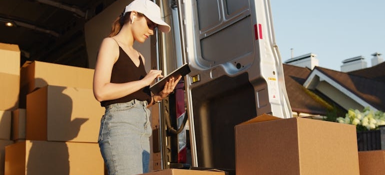 Woman doing inventory of boxes with movers Union City CA team