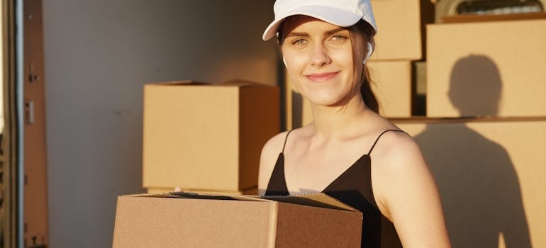 A team member of movers Benicia CA holding a cardboard box.