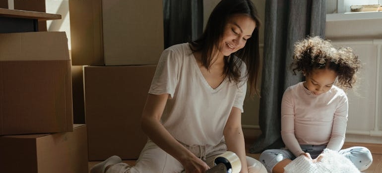 Woman packing for a move with her daughter.