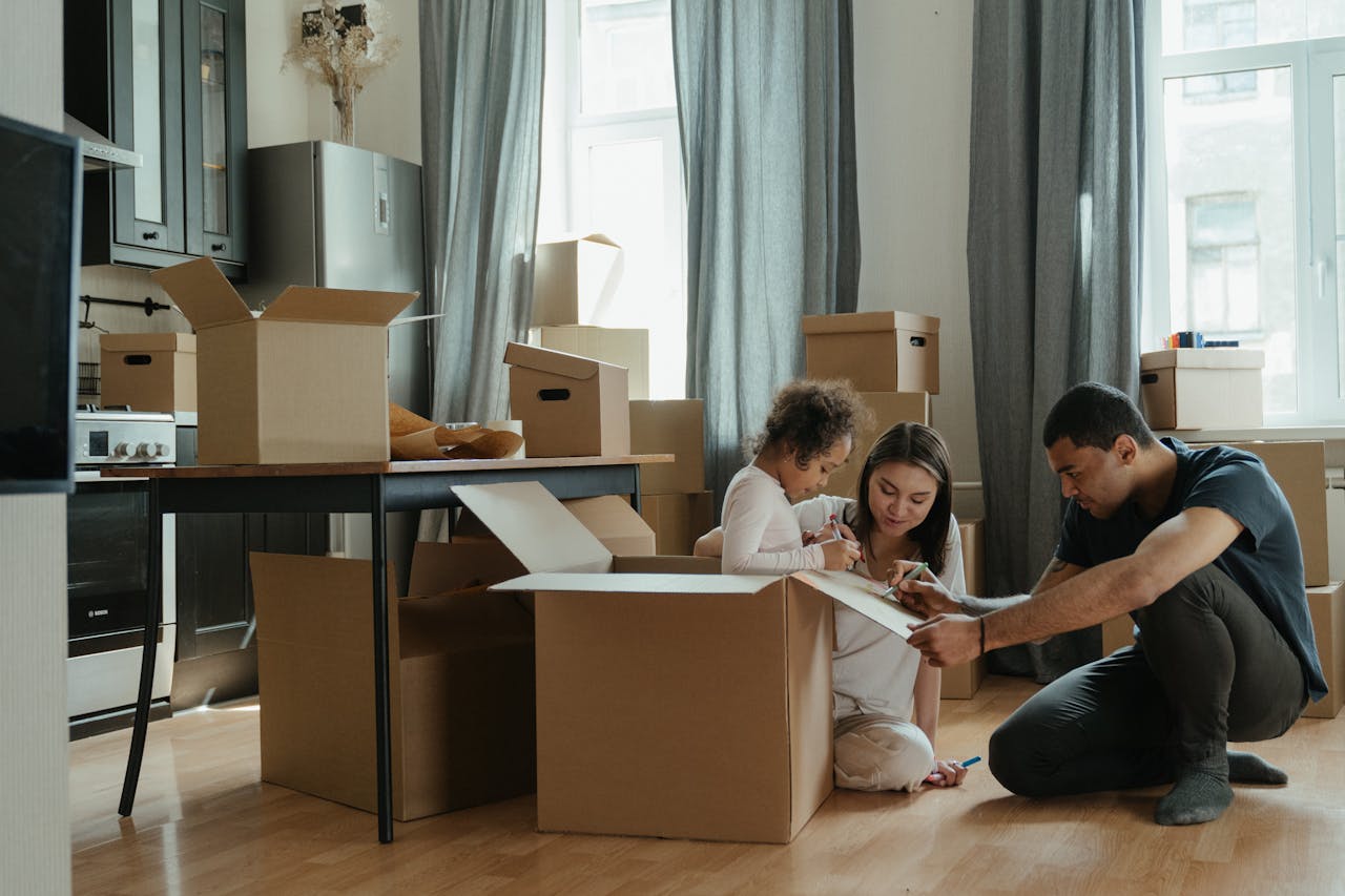 Couple packing moving boxes with their daughter.