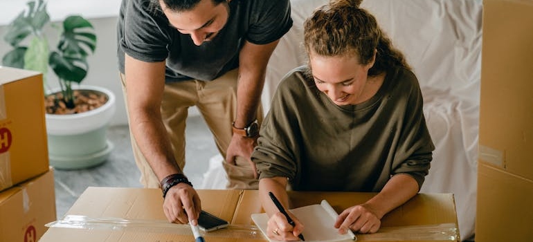 Couple writing their moving checklist.