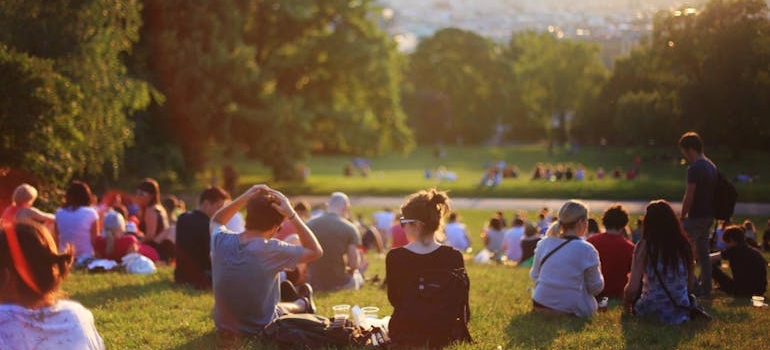 People sitting on grass in a park.