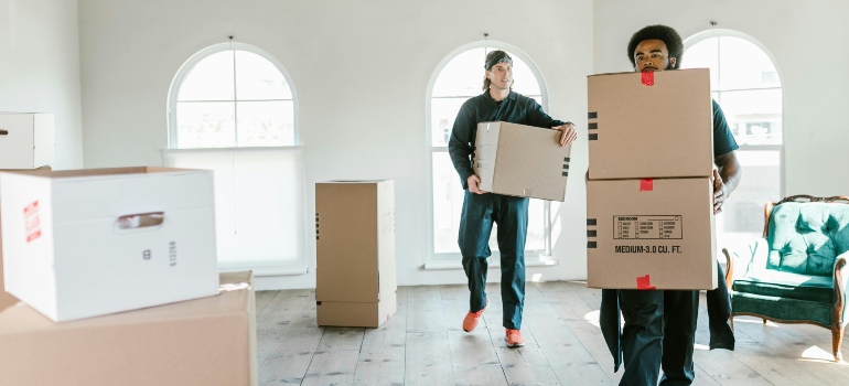 Two movers San Ramon CA residents recommend, carrying boxes in a bright room, offering reliable moving services.