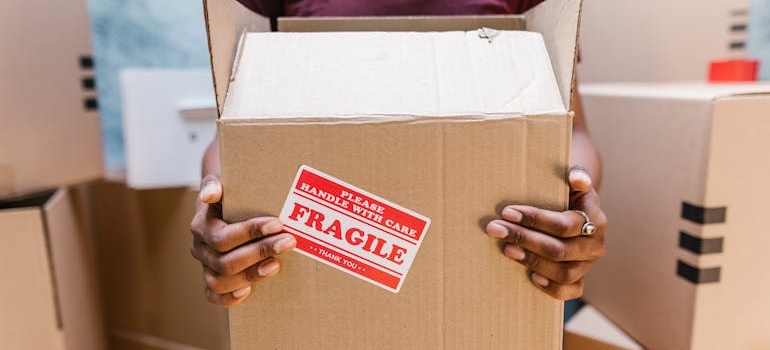 Person holding a box labeled fragile.