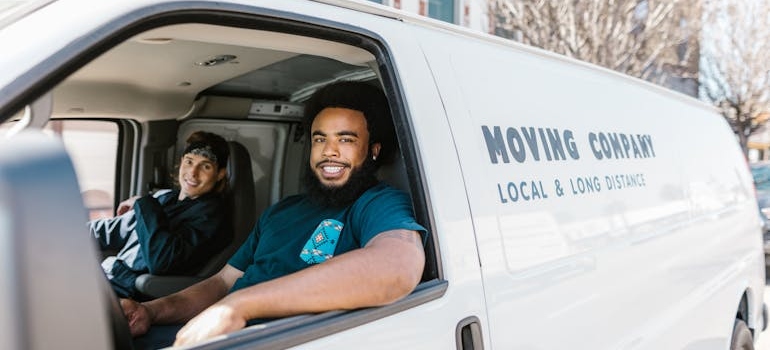 Two movers in Hayward CA driving a moving truck.