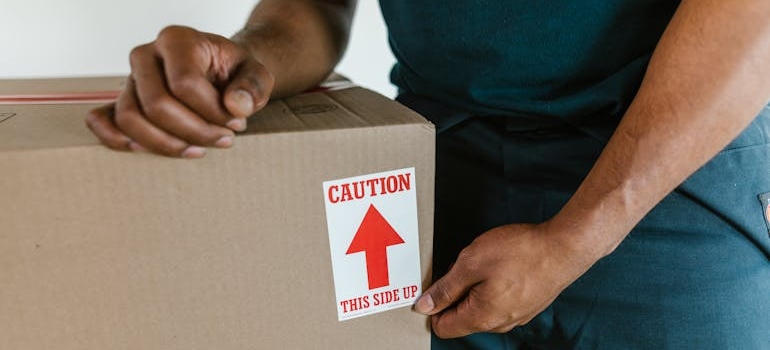 Man holding a box labeled fragile.