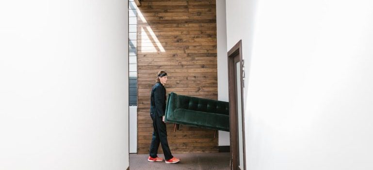 man holding green sofa