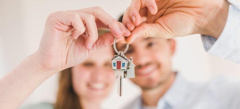 couple holding keys after winter moving in California