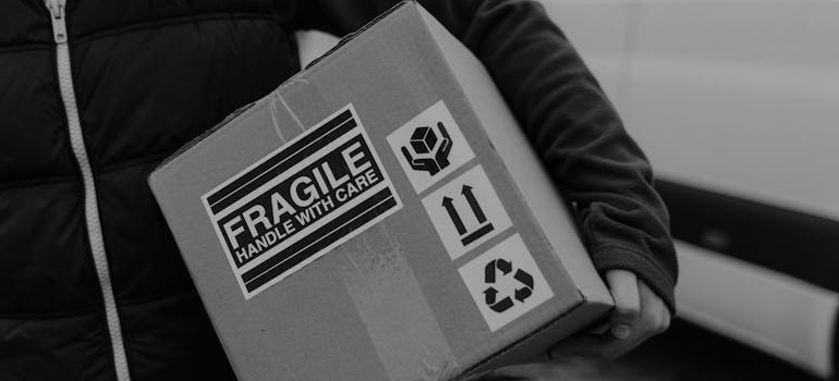 Person carrying a box labeled fragile.