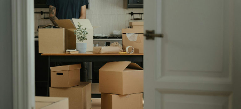 man standing near brown boxes