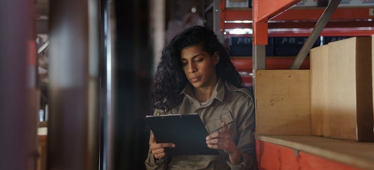 Woman checking the inventory on her clipboard.