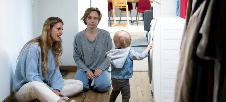 Two nannies taking care of a young child to help make moving with kids easier.