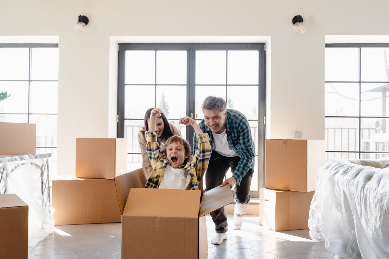 Parents pushing their son in a cardboard box.