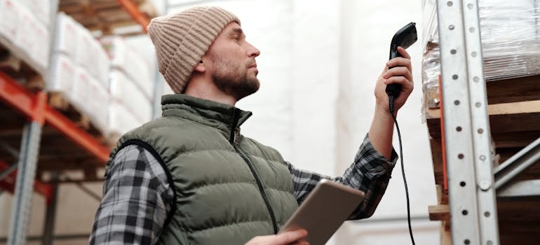 Man doing inventory by scanning items with a barcode scanner.