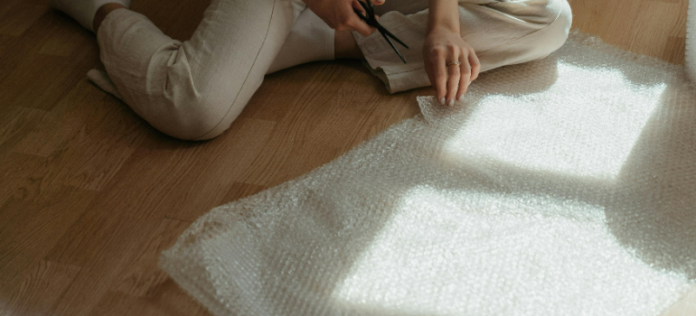 a girl cutting bubble wrap for moving to Concord CA