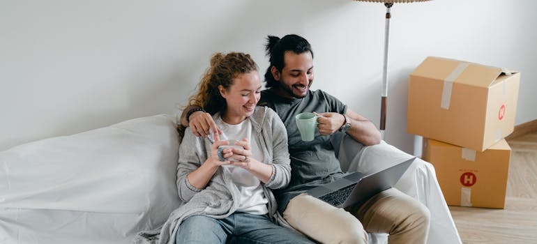 Couple looking at their laptop after completing their moving to California checklist.