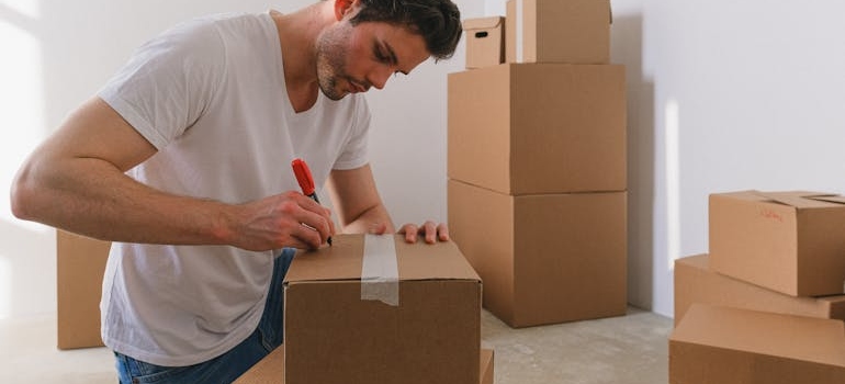 Man labeling a box, which can help you when moving your business to California.