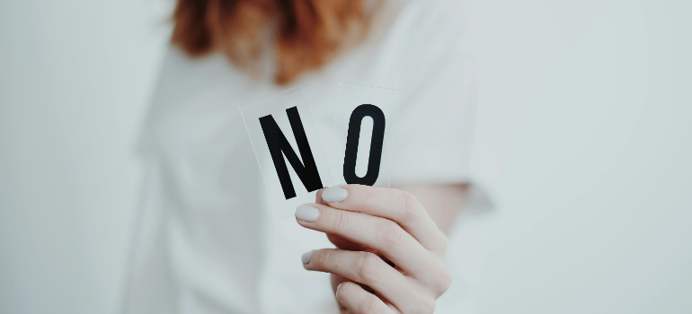 a woman holding a "no: sign 