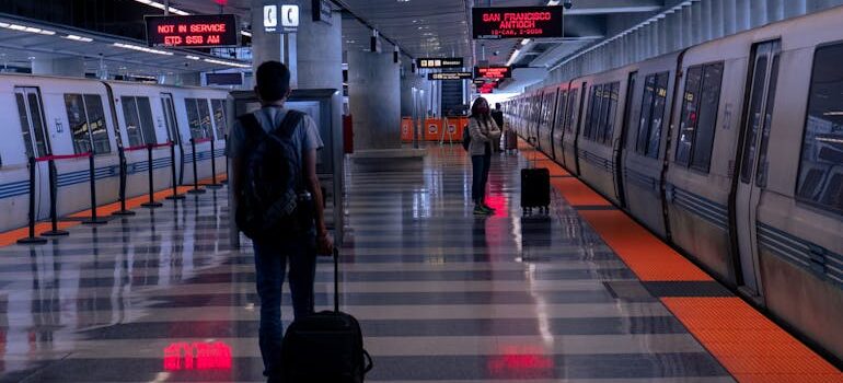 A Man Holding his Luggage Walking on Train Station