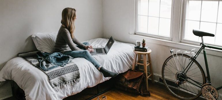 Woman in Gray Shirt Sitting on Bed