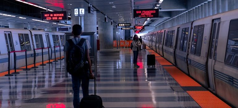 A Man Holding his Luggage Walking on Train Station