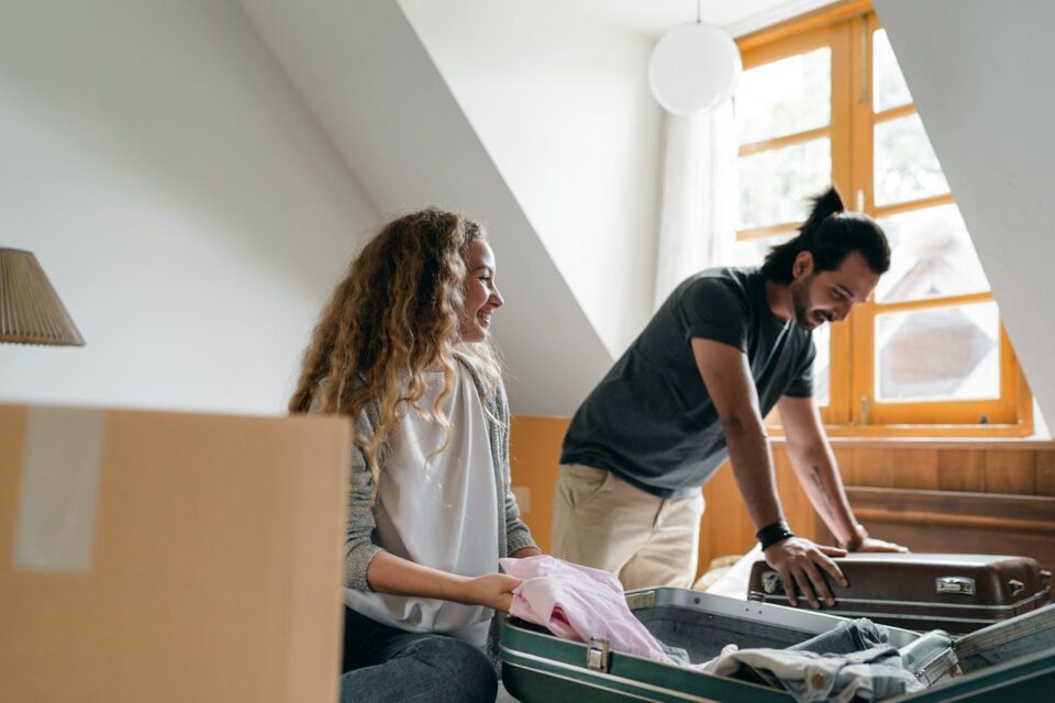 couple packing suitcases and carton boxes