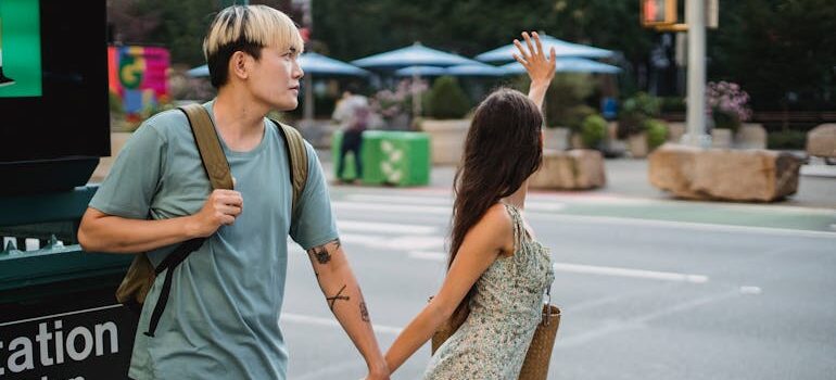 Young diverse couple catching cab on sidewalk